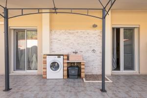 a washer and dryer outside of a house at Ibiscus Rosa 2 in Geremeas