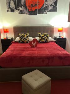 a bedroom with a red bed with two pillows at Vanvitelli Home in Caserta