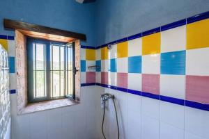 a colorful bathroom with a window and ailed wall at Casa Cortijo en Dehesa Sierra León in La Puebla de los Infantes +28 photos