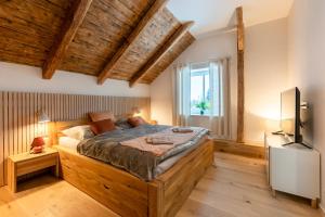 sypialnia z dużym drewnianym łóżkiem i telewizorem w obiekcie Wellness Apartmány Vila Republika w mieście Velké Losiny