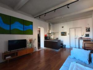a living room with a blue couch and a flat screen tv at Mount Flower Trastevere Apt in Rome