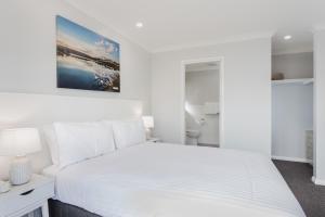 a white bedroom with a large white bed at Quality Apartments Banksia Albany in Albany