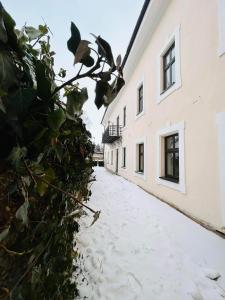 a snow covered alleyway between two buildings at V ulicke in Kežmarok