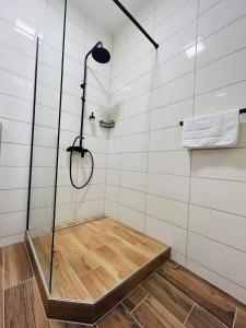 a shower with a glass enclosure and a wooden floor at V ulicke in Kežmarok