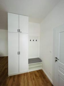 une pièce vide avec des armoires blanches et du parquet dans l'établissement V ulicke, à Kežmarok