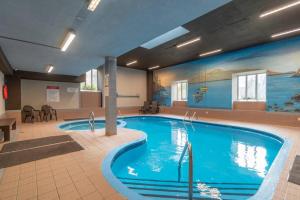 a large swimming pool in a hotel room at Au p'tit cocon sur le lac in Magog-Orford