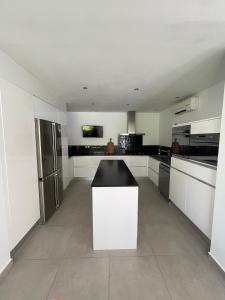 a kitchen with white cabinets and a black counter top at U0616 - Magnifique villa avec piscine proche Nice, Cannes in Roquefort-les-Pins