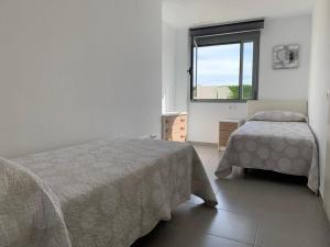 sypialnia z dwoma łóżkami i oknem w obiekcie Casa Grullo w mieście Conil de la Frontera