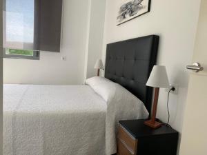 sypialnia z łóżkiem z czarnym zagłówkiem i lampką w obiekcie Casa Grullo w mieście Conil de la Frontera +30 zdjęć