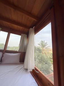 a bed in a room with a window at Mangrove Camp Fayoum in ‘Ezbet Ilyâs