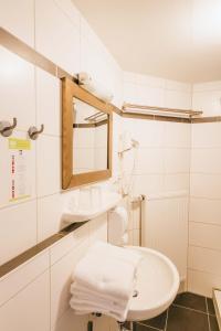 Baño blanco con lavabo y espejo en Hotel Andres, en Bamberg