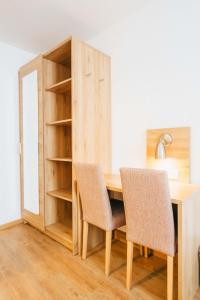 a wooden desk with two chairs and a book shelf at Hotel Andres in Bamberg
