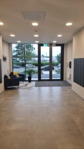 ルートンにあるLovely Apartment near Luton Airport One Bedroom 416のリビングルーム(大きなガラスドアのあるロビー付)