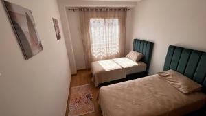 um pequeno quarto com 2 camas e uma janela em Luxury Family Appart 7 Pers - CheckPoint - Oujda Center em Oujda