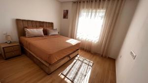 a bedroom with a large bed and a window at Luxury Family Appart 7 Pers - CheckPoint - Oujda Center in Oujda