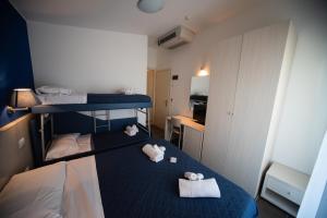 Habitación pequeña con 2 literas y toallas en Hotel Alabama, en Riccione