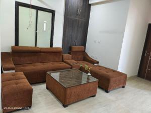 OSHO Villa Guest House في جايبور: غرفة معيشة مع أريكة وطاولة قهوة