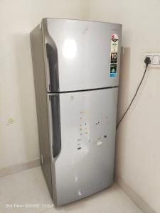 a stainless steel refrigerator in a corner of a room at OSHO Villa Guest House in Jaipur