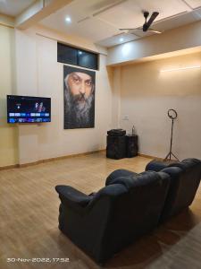 a living room with a couch and a tv at OSHO Villa Guest House in Jaipur