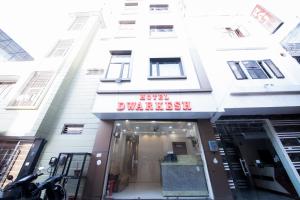 Perfect Stayz Dwarkesh - Hotel Near Haridwar Railway station في حاريدوار: مبنى ابيض مع لافته مكتوب عليها الفندق بالاسفل