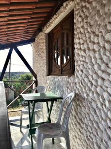 a table and chairs on a patio with a window at Falésias de Carapibus in Conde