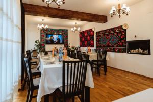 een eetkamer met een tafel en stoelen en een televisie bij Piatra Soimului in Vişeu de Sus