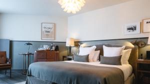 a bedroom with a large bed and a chandelier at Le Fitz Roy, a Beaumier hotel in Val Thorens