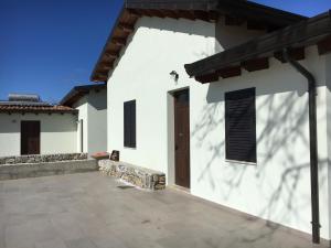 a white building with a door and a patio at Azienda agricola Crilù in Milazzo