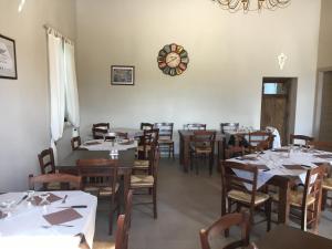 uma sala de jantar com mesas e cadeiras e um relógio na parede em Azienda agricola Crilù em Milazzo