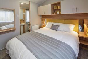 a bedroom with a large white bed and a window at Golden Sands Retreat in Mablethorpe