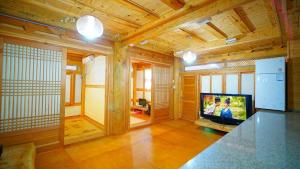 a living room with a television in a wooden house at Kumwondang Jeonju Hanokstay in Jeonju