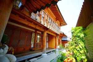 a building with a porch and a building with windows at Kumwondang Jeonju Hanokstay in Jeonju