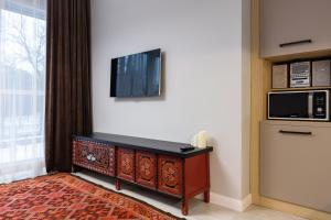Una sala de estar con un televisor en la pared. en Central Park View, en Almaty