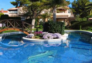 una gran piscina con un puente y flores en Doree 449, en Bonmont Terres Noves