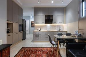 Una cocina con gabinetes blancos y una mesa con sillas. en Central Park View, en Almaty