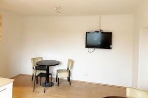 a room with a table and chairs and a tv on the wall at cozy 2-room Apartment in Brühl