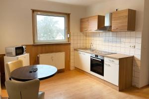 een keuken met een tafel en een tafel en een magnetron bij cozy 2-room Apartment in Brühl