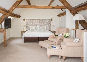 a bedroom with a bed and two chairs at Lords Of The Manor in Upper Slaughter