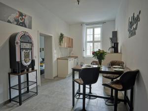 eine Küche und ein Esszimmer mit einem Tisch und einem TV in der Unterkunft "HOGULU" Brandenburg, Im Herzen der Altstadt, Stilvoll, Küche in Brandenburg an der Havel