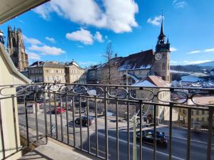 a balcony with a view of a street and a church at Appartement tout confort rénové avec vue - Tilleul 5 in Fribourg