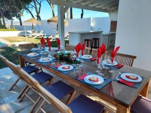 a wooden table with red napkins and glasses on it at TESS Villa Maria in Alhaurín de la Torre