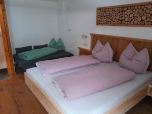 a room with two beds with purple pillows at Haus Rottensteiner in Jerzens