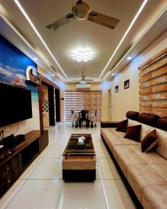 a living room with a couch and a flat screen tv at Exquisite 2BHK de Luxe boutique apartment. in Kulurkudrū