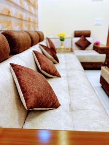 a long couch with pillows on it in a living room at Exquisite 2BHK de Luxe boutique apartment. in Kulurkudrū