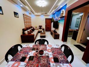 a dining room with a table and a living room at Exquisite 2BHK de Luxe boutique apartment. in Kulurkudrū