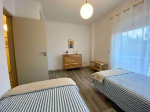 um quarto com 2 camas e uma cómoda e uma janela em Rocha’s Apartment REMODELADO! Na praia com terraço em Vila Nova de Gaia