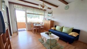 ein Wohnzimmer mit einem blauen Sofa und einem Tisch in der Unterkunft ROBERTO Haus KMB Seeappartement direkt am Ossiacher See mit Hallenbad in Tschöran