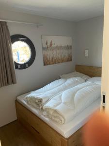 a large bed in a room with a window at Waidlerland Hausboot 1 in Waldkirchen