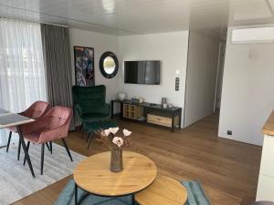 a living room with a vase of flowers on a table at Waidlerland Hausboot 1 in Waldkirchen