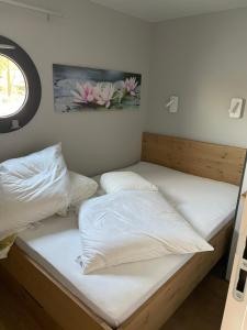 two beds in a room with white sheets at Waidlerland Hausboot 1 in Waldkirchen
